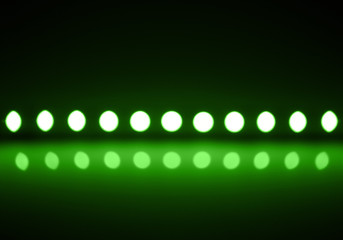 Play of green light on defocusing blur led lamps background