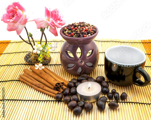 Tea ceremony by candlelight with cinnamon, roses, cup, pepper mix isolated on white
