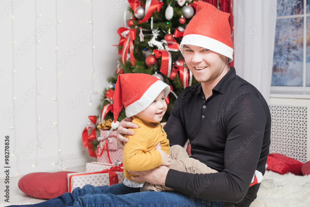 Fototapeta premium Happy father with son at Christmas eve sitting together