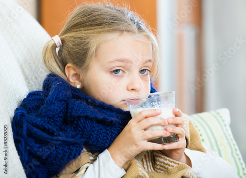 Little girl having heavy quinsy in domestic interior photo