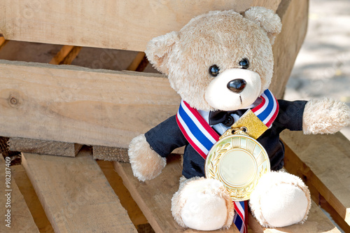 old gold medal in teddy bear at park public background, blank fa photo