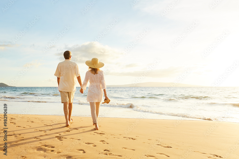 Mature Couple Walking on the Beach at Sunset Mature Couple Walking on the Beach at Sunset