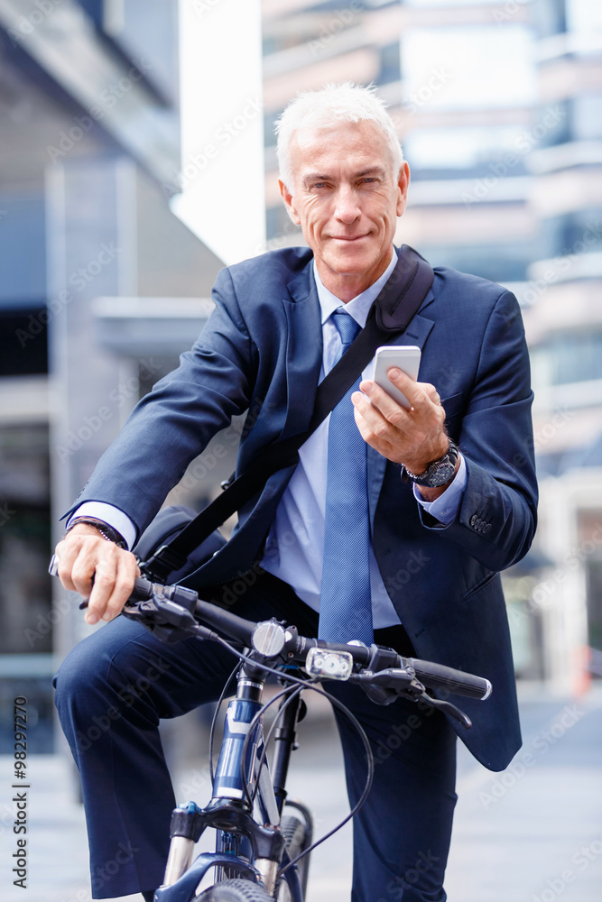 Successful businessman on bicycle with mobile phone Successful businessman on bicycle with mobile phone