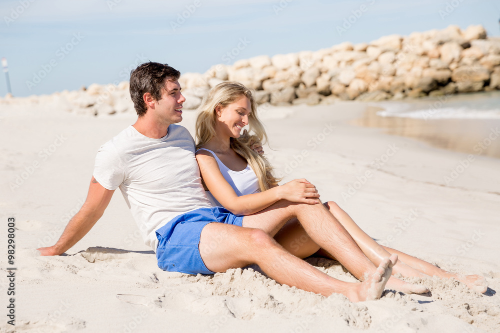 Romantic young couple sitting on the beach Romantic young couple sitting on the beach