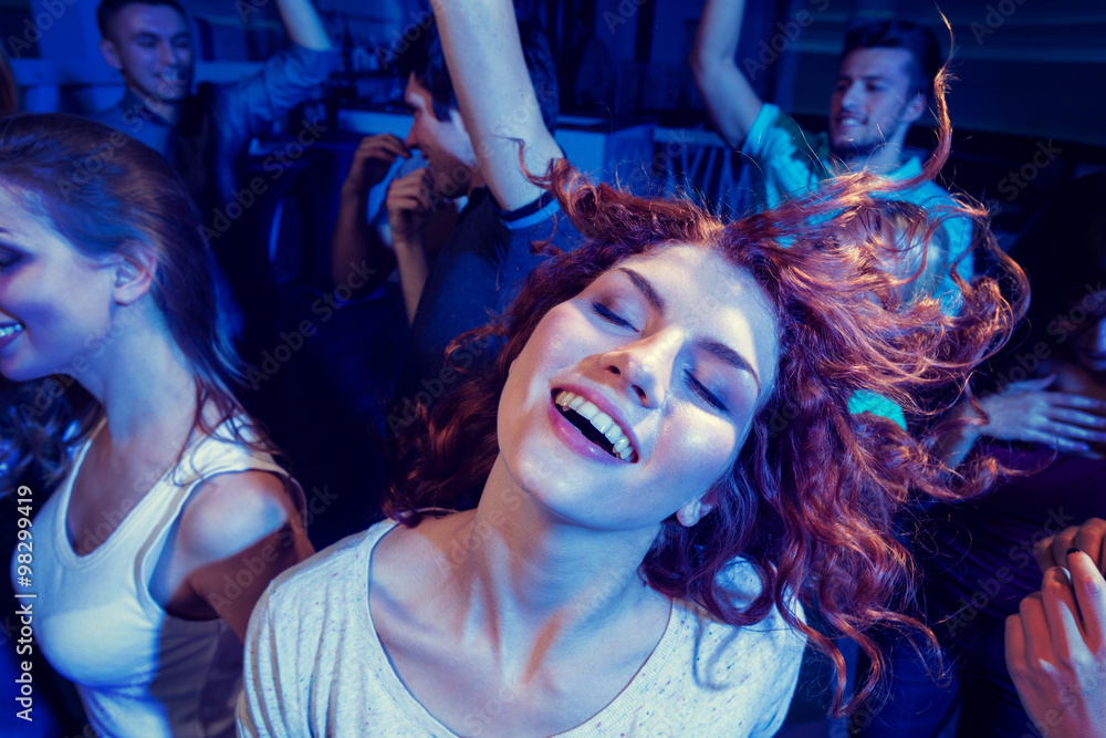 Fototapeta premium smiling friends dancing in club