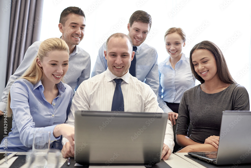 smiling business people with laptop in office smiling business people with laptop in office