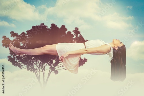 Composite image of girl in white dress floating in air