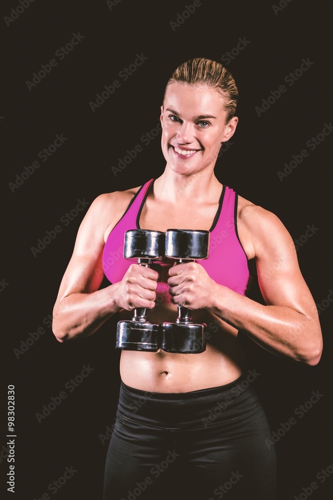 Composite image of muscular woman lifting heavy dumbbells Composite image of muscular woman lifting heavy dumbbells