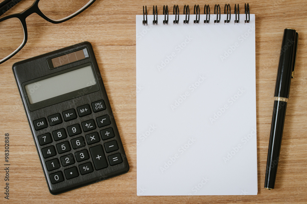 calculator, notepad ,pen and eyeglasses on wooden background calculator, notepad ,pen and eyeglasses on wooden background