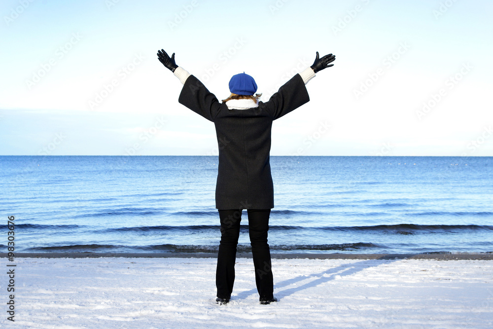 pregnant lady spreading her arms above winter sea pregnant lady spreading her arms above winter sea