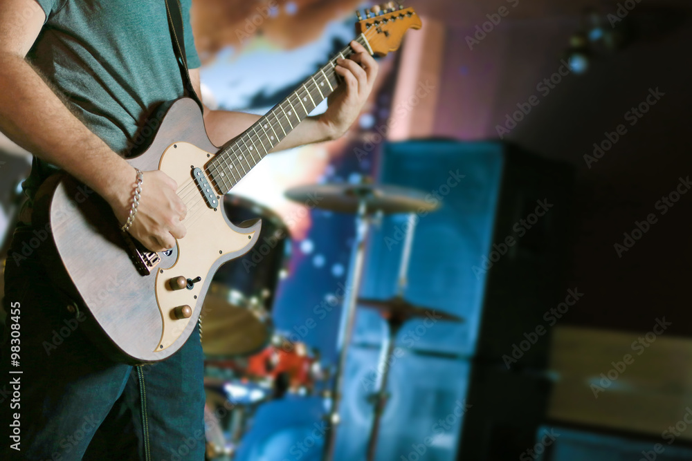 Fototapeta premium Young man playing on electric guitar close up
