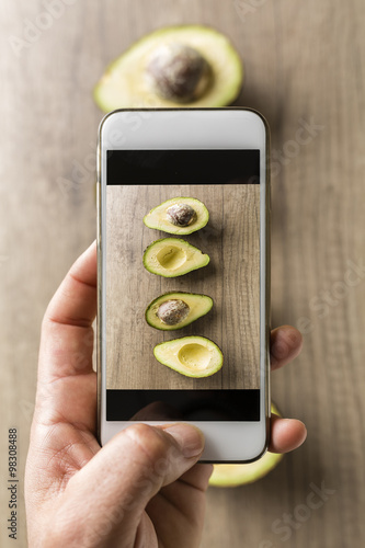 Avocados on a wooden table. Mobile photography