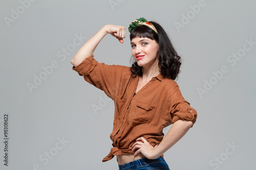 Beautiful positive happy young woman showing biceps photo