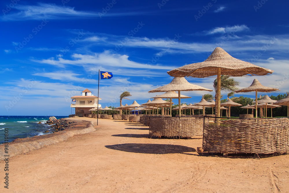 beach with sun beds and umbrellas, Egypt summer shore