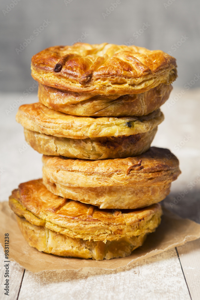 Stack of homemade meat pies on a rustic table Stack of homemade meat pies on a rustic table