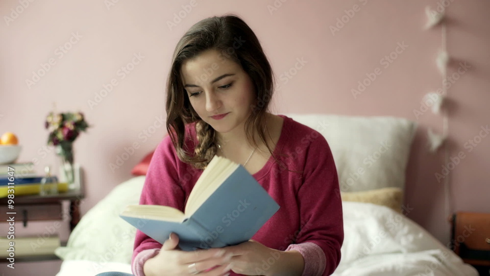 Teenage girl answering her phone while reading book in bedroom
Teenage girl answering her phone while reading book in bedroom