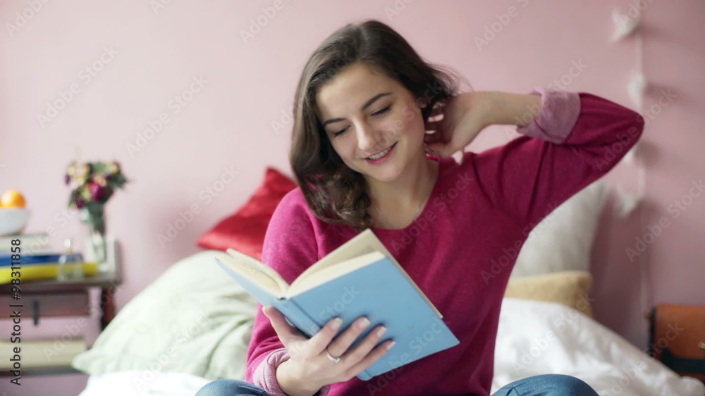 Happy teenager reading book in her bedroom and stretching muscles
Happy teenager reading book in her bedroom and stretching muscles