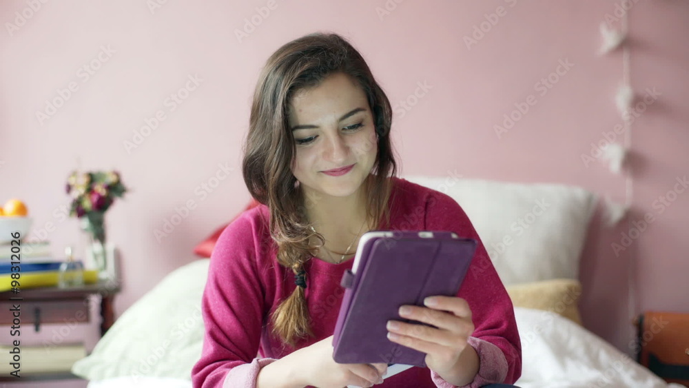 Teenage girl browsing internet on tablet and typing message on smartphone
Teenage girl browsing internet on tablet and typing message on smartphone