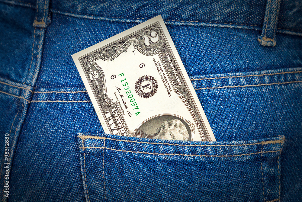Two dollars bill sticking out of the back jeans pocket Two dollars bill sticking out of the back jeans pocket
