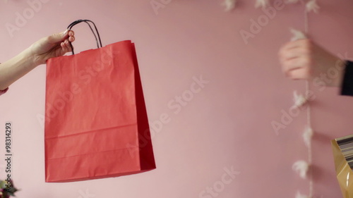 Boy giving christmas presents to a girl in bedroom
