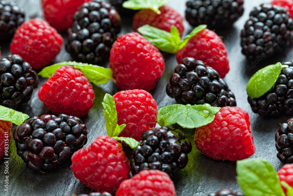 Heap of raspberry and blackberry on stone Heap of raspberry and blackberry on stone