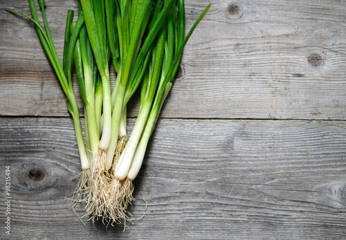 Fresh spring onion on wooden background
