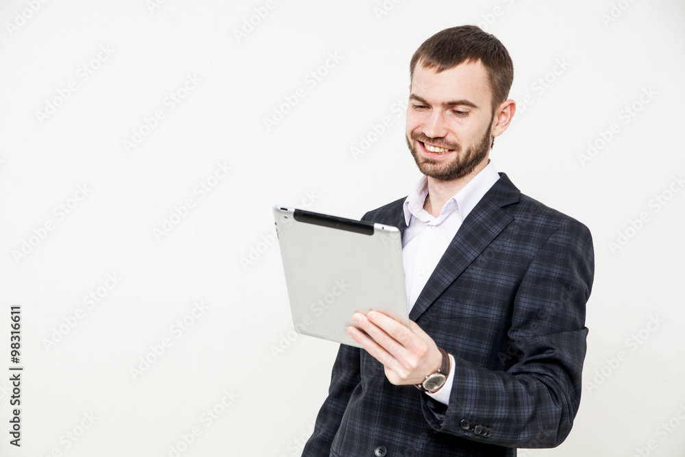 Portrait of a handsome young bearded man wearing a formal black suit holding a tablet Portrait of a handsome young bearded man wearing a formal black suit holding a tablet