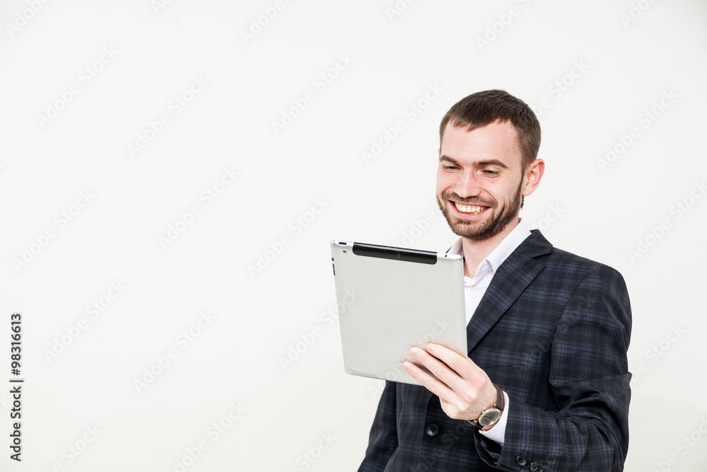 Portrait of a handsome young bearded man wearing a formal black suit holding a tablet Portrait of a handsome young bearded man wearing a formal black suit holding a tablet