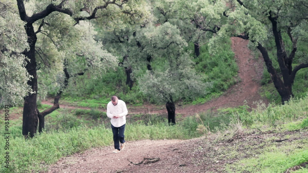 Young, lost man with smartphone looking for direction in park Young, lost man with smartphone looking for direction in park