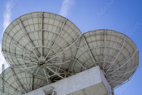 Satellite dishes on background sky