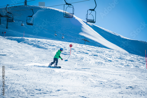 Female snowboarder running down in the mountains. Italian alps, Livigno. Resort Mottolino. photo