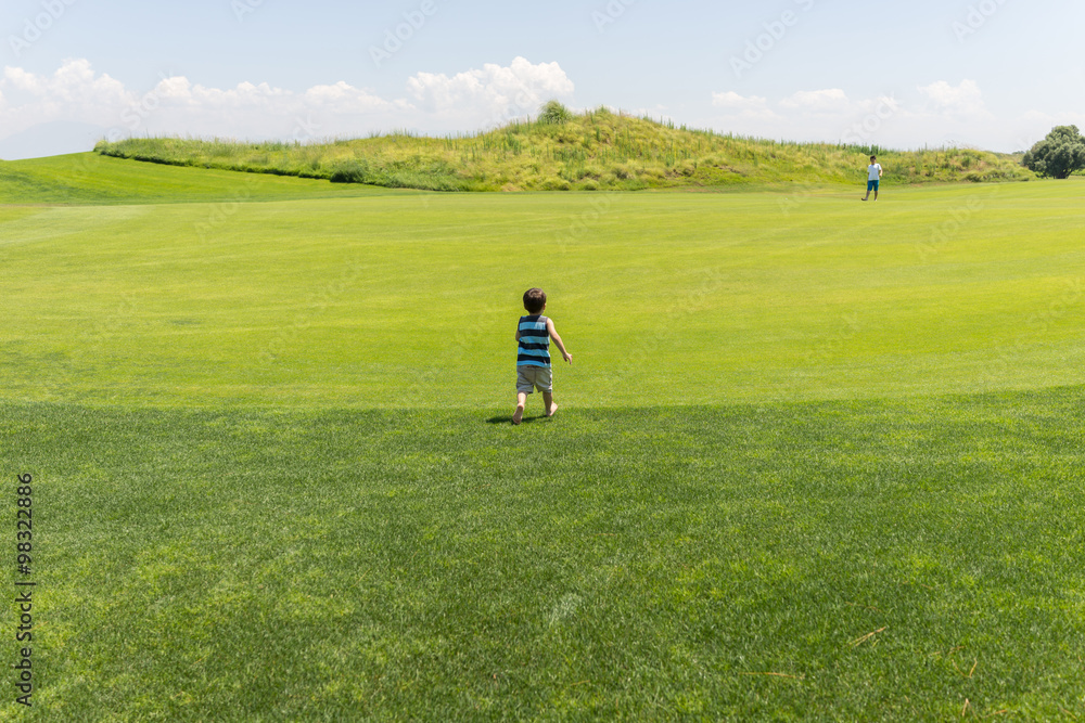 Little kid running on green meadow Little kid running on green meadow