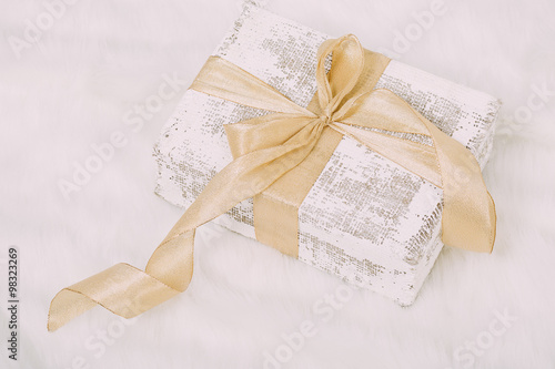 Shabby chic gift with golden ribbon on white background