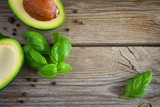 Food background with avocado and basil on old wooden boards. Top