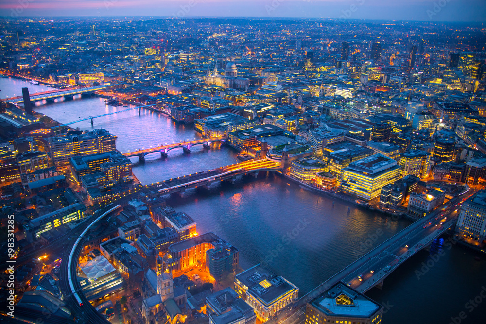 City of London panorama at sunset. River Thames, bridges and lit up streets aerial view