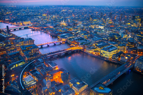 City of London panorama at sunset. River Thames, bridges and lit up streets aerial view