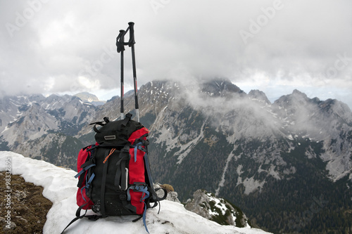 Mountaineering equipment. Rucksack and ski poles on the mountain summit. Location Begunjscica, Slovenia