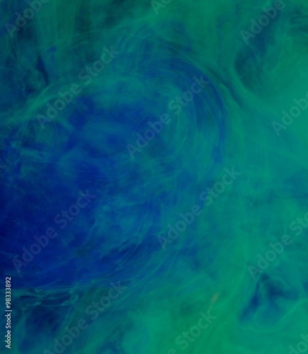 Blue green clouds of ink in liquid