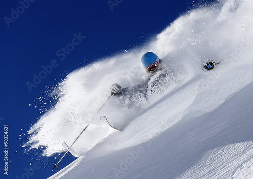 A freeride skier makes a turn in powder snow on a sunny day in western Austria photo
