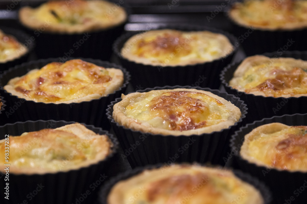 Mini quiche Lorraine - traditional French pie with ham, leeks, b Mini quiche Lorraine - traditional French pie with ham, leeks, b