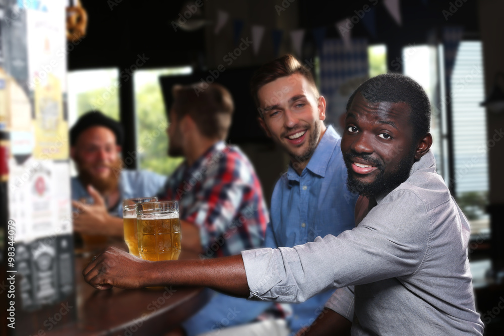 Young men drinking beer in pub