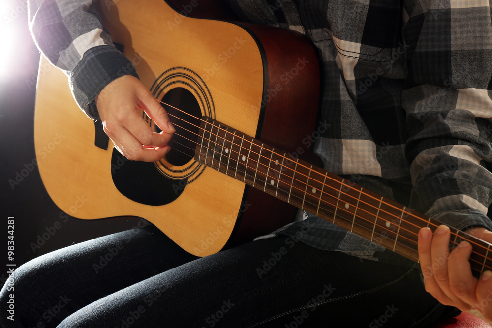 Fototapeta premium Guitarist plays guitar in the studio, close up