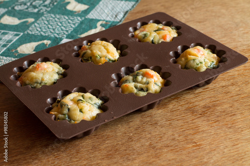 Εκτύπωση καμβά Muffin with salmon, spinach and cheese in silicone bakeware on green tablecloth with gooses
