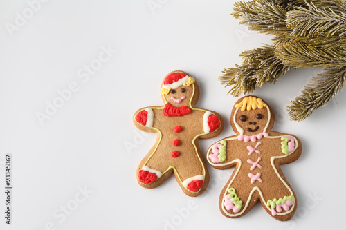 Two gingerbread men on white with pine