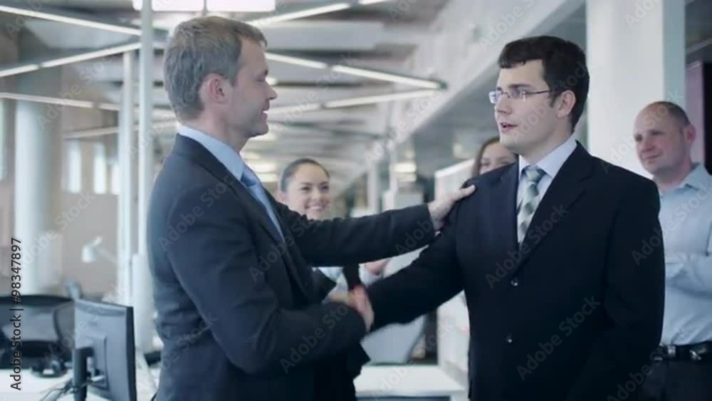 Team Congratulating Coworker with Promotion. Shot on RED Cinema Camera Team Congratulating Coworker with Promotion. Shot on RED Cinema Camera