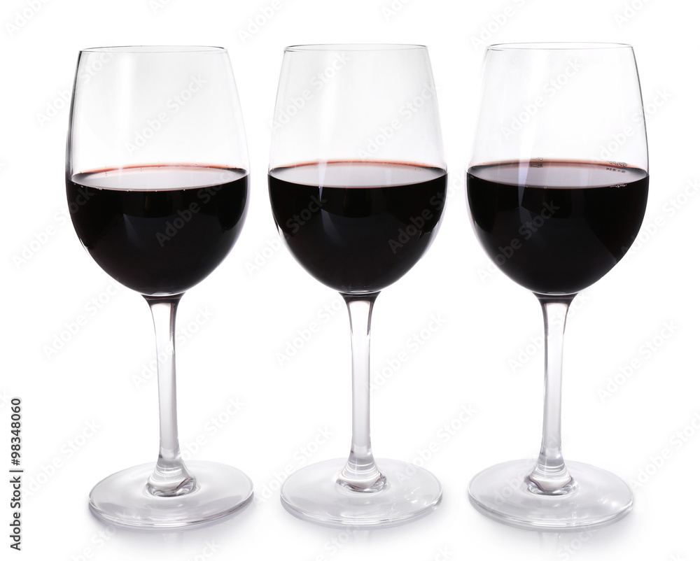 Three glasses of red wine on light background