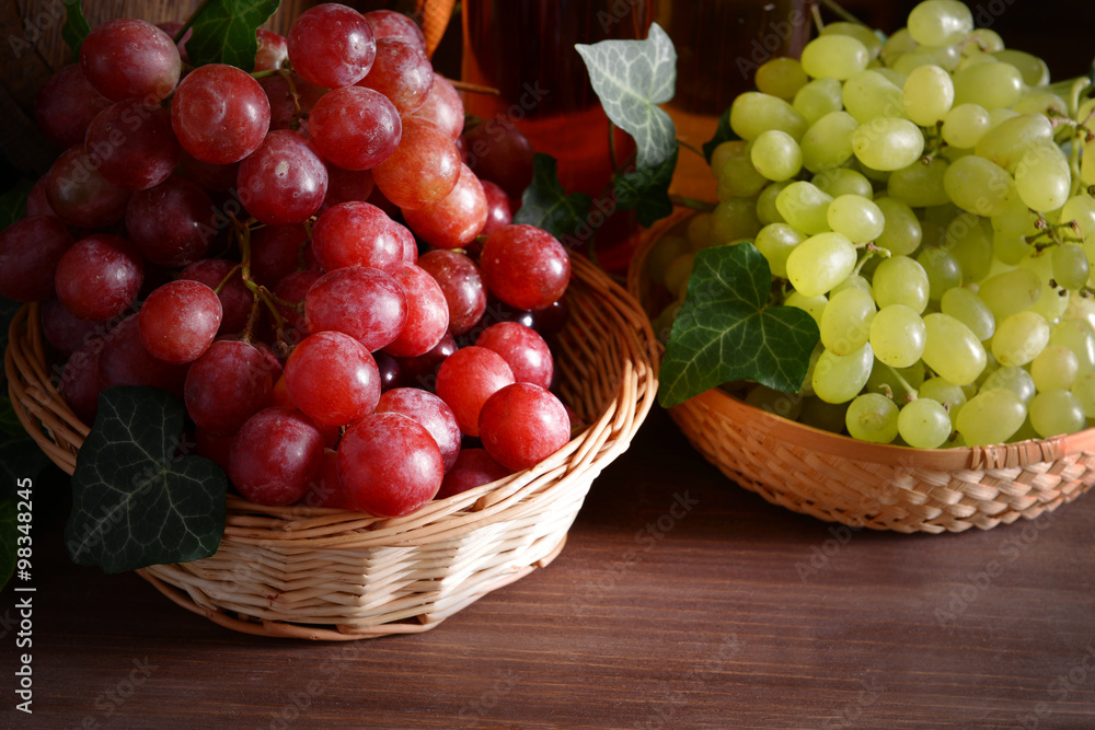 Grape in wicker bowls on wooden table Grape in wicker bowls on wooden table