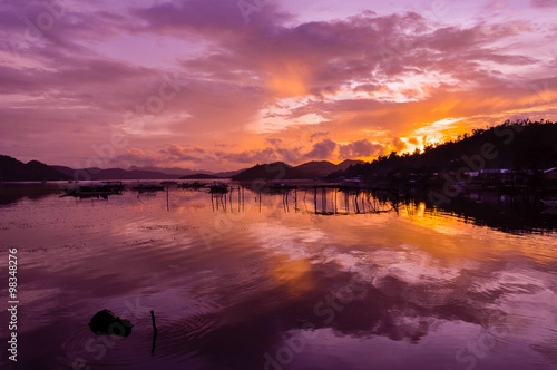 Pretty Pink orange Sky cloudscape over an island with reflection at Sunset on the Island of Coron