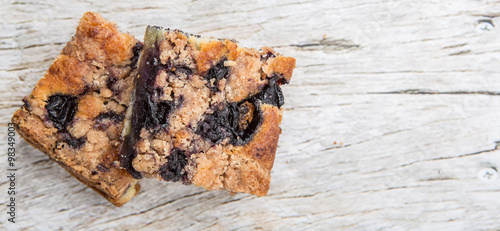 Portions of delicious homemade blueberry sponge cakes over wooden background