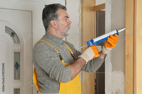 Obraz na plátně Home renovation, caulking door with silicone